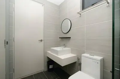a bathroom with a toilet and a sink and a mirror at Cozy Skyline Retreat at Trion KL, Level 63 in Kuala Lumpur
