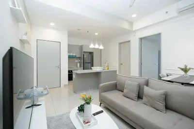 a living room with a couch and a kitchen at Cozy Skyline Retreat at Trion KL, Level 63 in Kuala Lumpur