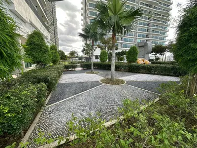a walkway with two palm trees and a building at Datum Jelatek Sky Resident KLCC by Deen in Kuala Lumpur