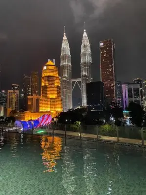 a city skyline at night with a pool of water at Legasi Al Rahmat Kampung Baru in Kuala Lumpur