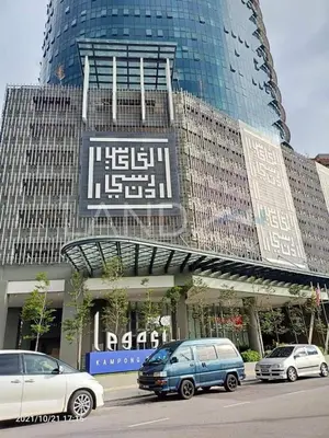 a large building with cars parked in front of it at Legasi Al Rahmat Kampung Baru in Kuala Lumpur