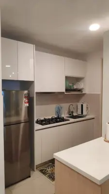 a kitchen with white cabinets and a stainless steel refrigerator at Legasi Al Rahmat Kampung Baru in Kuala Lumpur