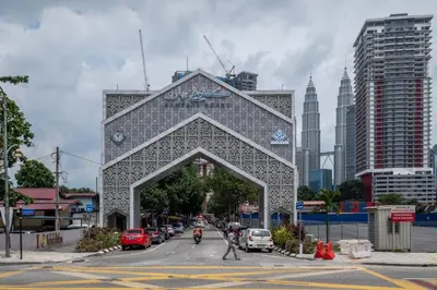 a building with an arch in the middle of a city at Legasi Al Rahmat Kampung Baru in Kuala Lumpur