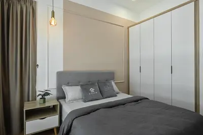 a bedroom with a large bed with gray sheets and pillows at Razak City Residence in Kuala Lumpur