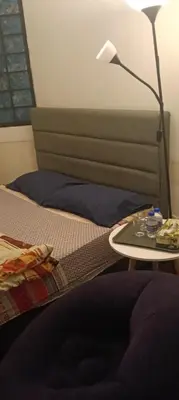 a bed with a table with a lamp on it at EMPRESS SIGNATURE in Kuala Lumpur