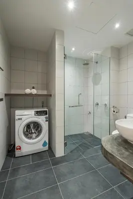 a bathroom with a washing machine and a sink at Chambers Suites KL by Wabi Wood's House in Kuala Lumpur