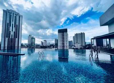 a swimming pool with a city skyline in the background at Chambers Suites KL by Wabi Wood's House in Kuala Lumpur