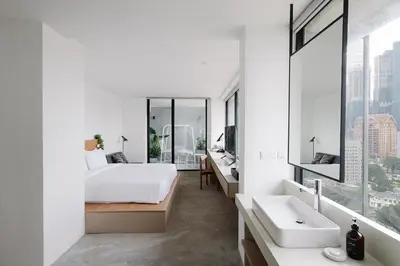 a bedroom with a bed and a sink and a mirror at Lloyd's Inn Kuala Lumpur in Kuala Lumpur