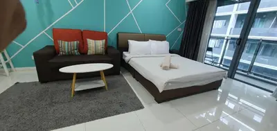a room with a bed and a chair and a table at Summer Suits Klcc by KL Residence in Kuala Lumpur