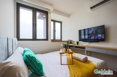 a living room with a couch and a flat screen tv at Infinity SkyPool - KL Suite KL Sentral Brickfield by GoMain in Kuala Lumpur