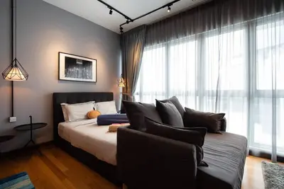 a bedroom with a bed and a couch in front of a window at Modern Studio @ Kuala Lumpur, Regalia Residence in Kuala Lumpur