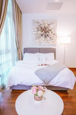 a bedroom with a bed and a table with flowers on it at 6 PAX, Studio, 3mins to KLCC (3A01) in Kuala Lumpur