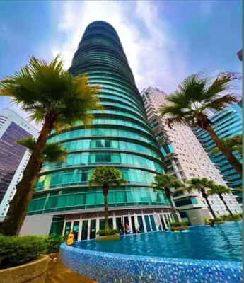a tall building with palm trees in front of it at Vortex Suites KLCC By SALEH in Kuala Lumpur