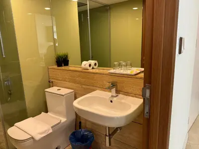 a bathroom with a sink and a toilet and a mirror at Vortex Suites KLCC By SALEH in Kuala Lumpur