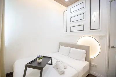 a white bedroom with a white bed and a table at V Residence at Sunway Velocity by MY TRIP & MY STAY in Kuala Lumpur