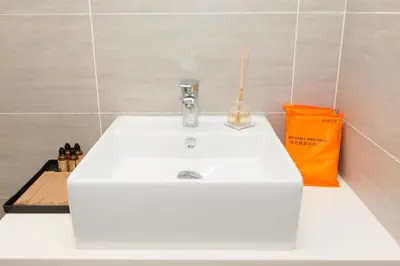 a white sink in a bathroom with an orange bag at Trion KL city centre near KLCC & TRX by MY TRIP & MY STAY in Kuala Lumpur