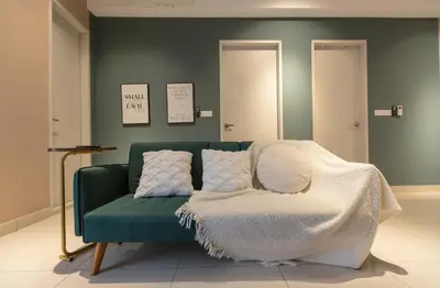 a green couch with a blanket on it in a room at Trion KL city centre near KLCC & TRX by MY TRIP & MY STAY in Kuala Lumpur