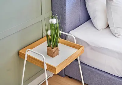 a small table with a plant on it next to a bed at Continew Residence TRX KL in Kuala Lumpur