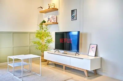 a living room with a tv and a white cabinet at Continew Residence TRX KL in Kuala Lumpur