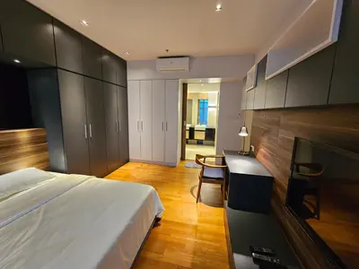 a bedroom with a bed and a desk and cabinets at Premier 2BR Suites, Dua Sentral in Kuala Lumpur