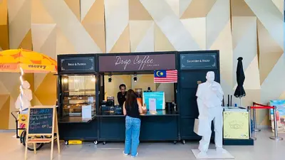 a woman standing in front of a pastry shop at Summer suites KLCC by cozy stay in Kuala Lumpur