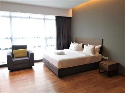 a hotel room with a bed and a chair at Imperial Suites @Bangsar by Plush in Kuala Lumpur