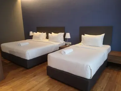 two beds in a hotel room with white sheets at Imperial Suites @Bangsar by Plush in Kuala Lumpur