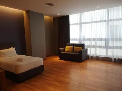 a bedroom with a bed and a couch and a chair at Imperial Suites @Bangsar by Plush in Kuala Lumpur