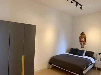 a bedroom with a bed and a cabinet in it at Continew by Plush Services in Kuala Lumpur