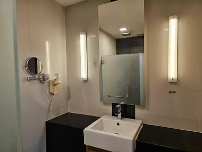 a bathroom with a sink and a mirror and a phone at Deluxe Family, Dua Sentral in Kuala Lumpur