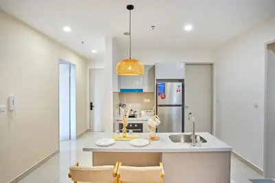 a kitchen with a sink and a counter with chairs at Trion Kuala Lumpur by Cobnb in Kuala Lumpur