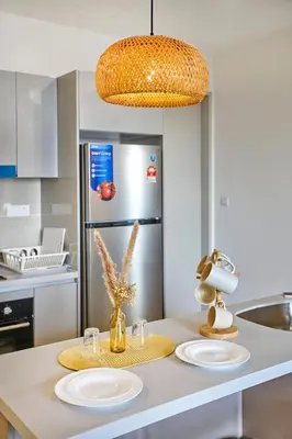 a kitchen with two plates on a counter with a refrigerator at Trion Kuala Lumpur by Cobnb in Kuala Lumpur