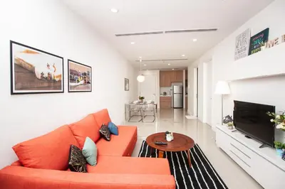 a living room with an orange couch and a table at Binjai 8 by Plush in Kuala Lumpur