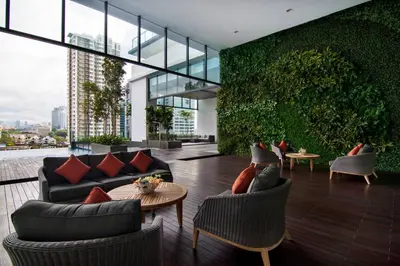 a living room with couches and a table at Nadi Bangsar by Plush in Kuala Lumpur