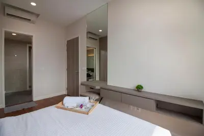 a bathroom with a white bed and a large mirror at Nadi Bangsar by Plush in Kuala Lumpur