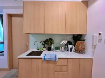 a kitchen with a sink and wooden cabinets at Comfy & Cozy Suites 3PX @ Colony, Near Monorail & Quill City Mall in Kuala Lumpur
