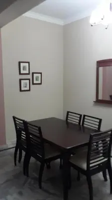 a dining room table with four chairs and a mirror at Golden City Apartment - Leisure Holiday Resorts in Kuala Lumpur