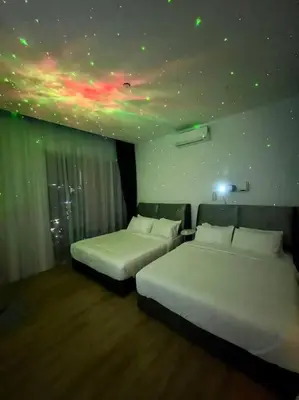 two beds in a hotel room with a star ceiling at SOGO PWTC KLCC Monorail link Quill Mall 7Pax in Kuala Lumpur