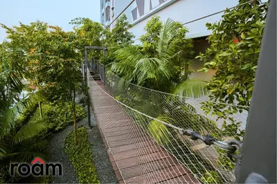 a chain link fence in front of a building with trees at Trion Kuala Lumpur by Roam in Kuala Lumpur
