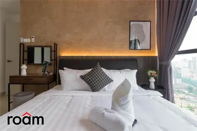 a bedroom with a large white bed with a window at Trion Kuala Lumpur by Roam in Kuala Lumpur