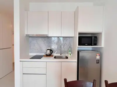 a kitchen with white cabinets and a stainless steel refrigerator at KLCC View with Balcony @ Chambers, KL Near LRT PWTC & Sunway Putra Mall in Kuala Lumpur