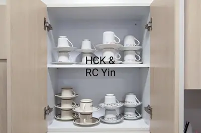 a cupboard with a bunch of hats and saucers at Lovely Family Suites at Razak City by HCK in Kuala Lumpur