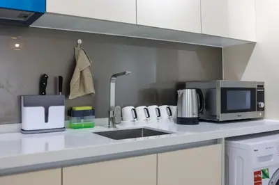 a kitchen counter with a sink and a microwave at Quill Residences KL By Minos Home in Kuala Lumpur