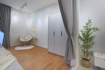 a bedroom with a bed and a chair and a mirror at Quill Residences KL By Minos Home in Kuala Lumpur