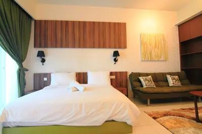 a bedroom with a white bed and a couch at Tribeca Residence Bukit Bintang in Kuala Lumpur