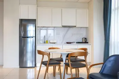a kitchen with a table and chairs and a refrigerator at Tribeca Residence Bukit Bintang in Kuala Lumpur