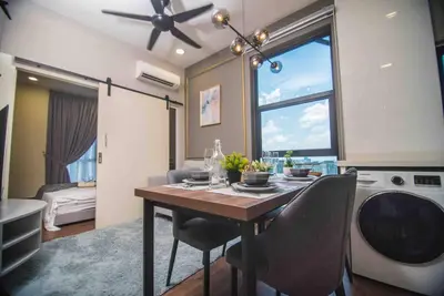 a kitchen with a dining room table with chairs and a washing machine at Arte Mont Kiara in Kuala Lumpur