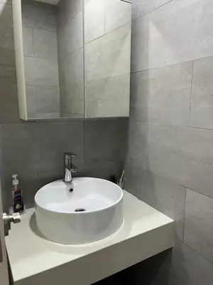 a bathroom with a white sink and a mirror at Arte Mont Kiara in Kuala Lumpur