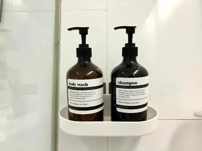 two bottles of shampoo sitting on a shelf in a bathroom at The Establishment Bangsar KL by Lynhomes in Kuala Lumpur