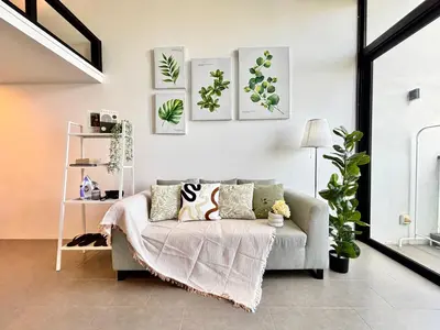 a living room with a couch and some plants at The Establishment Bangsar KL by Lynhomes in Kuala Lumpur